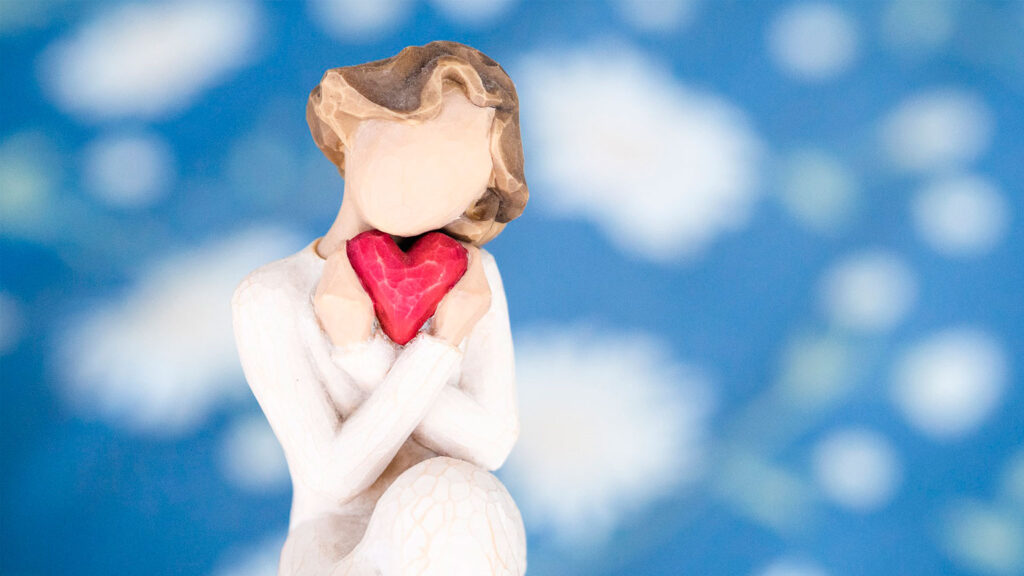 wooden carving of a woman holding a heart
