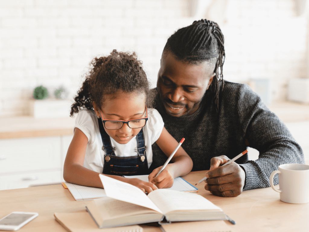 father helping daughter with her schoolwork at table