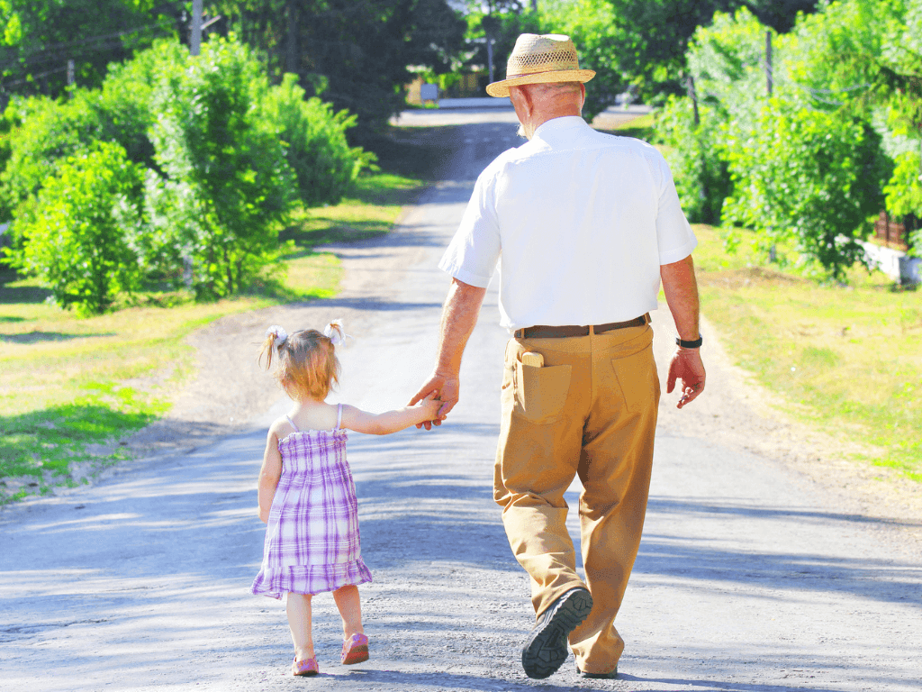 grandfather walking with his granddaughter