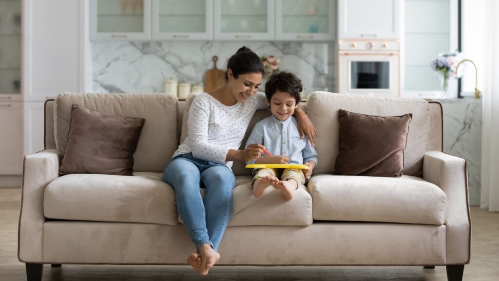 woman sitting on couch next to child