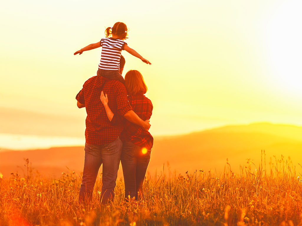 Mother standing next to a father with his daughter on his shoulders after a successful adoption in Dallas